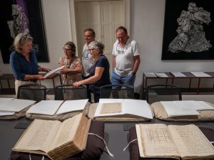 Descendants of William Stevens Notary Malta with Sarah Watkinson examining his original records at the Notarial Registers Archive.
