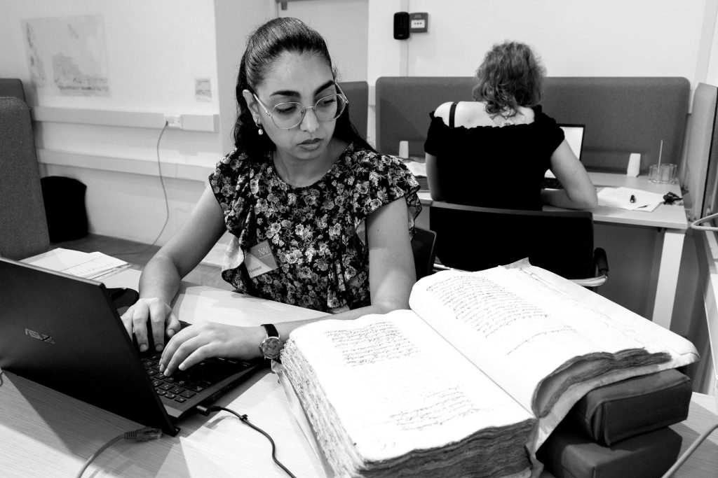 Photo of Marsha transcribing manuscript as a volunteer